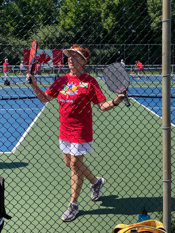 A player in a Canada shirt waving flags on court