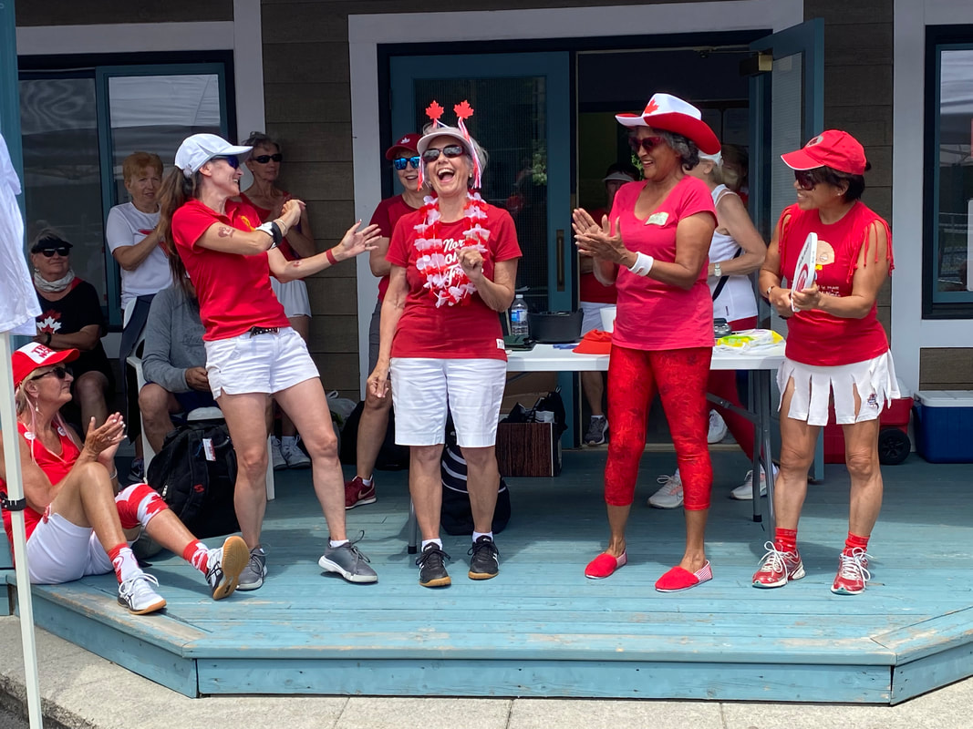 Women in red and white costumes on the clubhouse deck