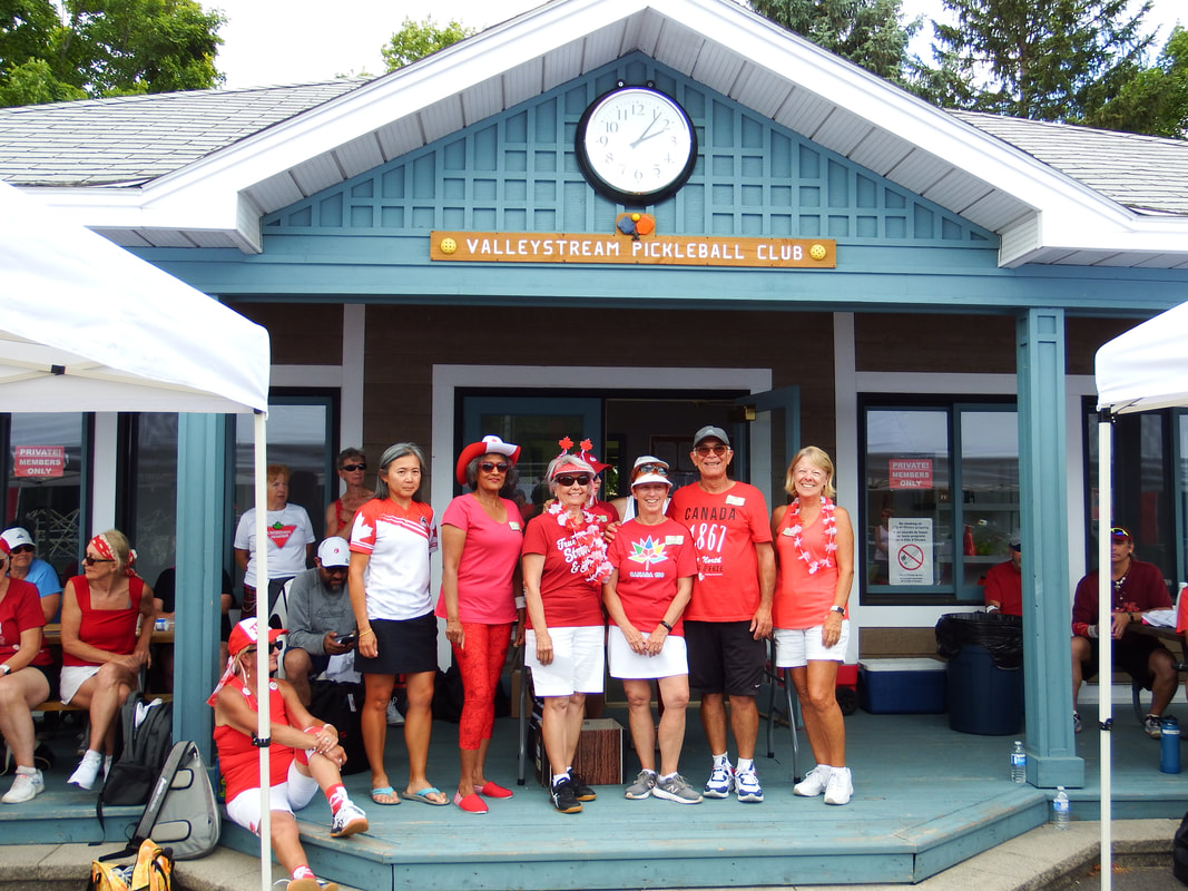 Members in red and white in front of the clubhouse